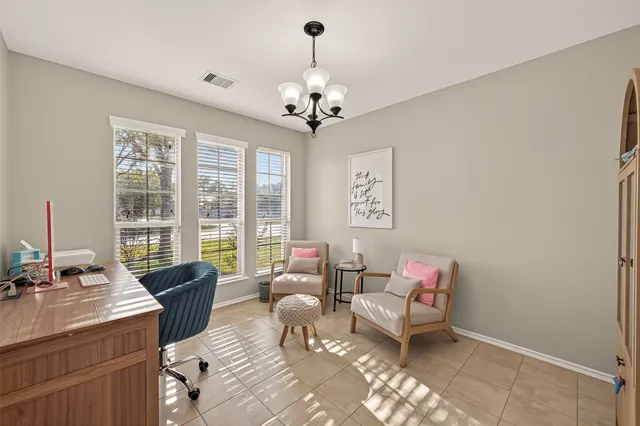 a living room with furniture two window and a chandelier