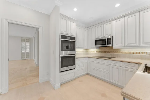 a kitchen with granite countertop white cabinets and sink