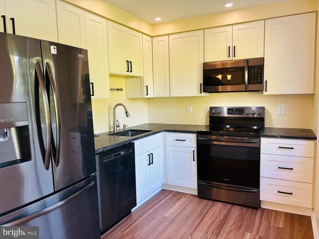a kitchen with stainless steel appliances granite countertop a refrigerator stove and sink