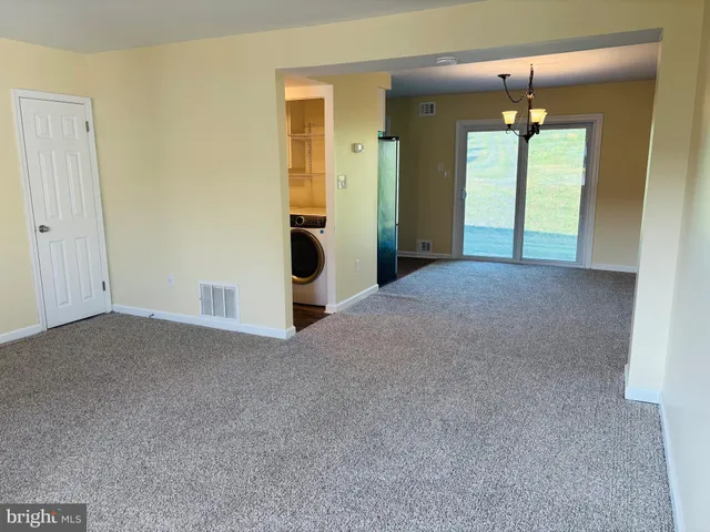 a view of an empty room with a fireplace and a window