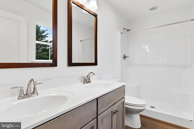 a bathroom with a sink toilet a mirror and shower