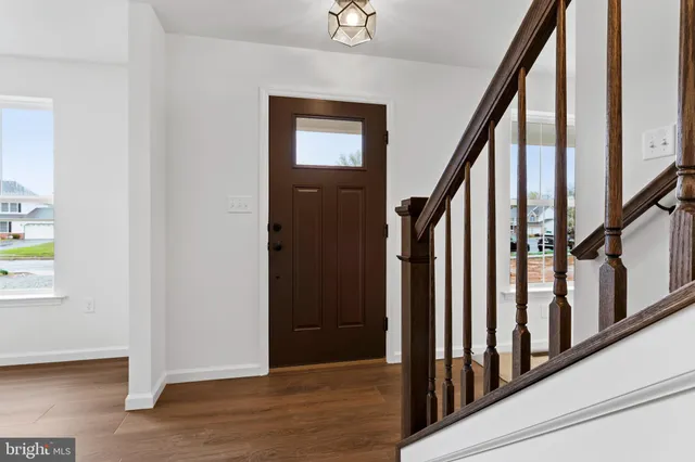 a view of an entryway with wooden floor and door