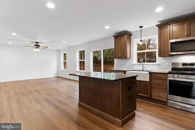 a kitchen with stainless steel appliances granite countertop a stove a sink and a microwave