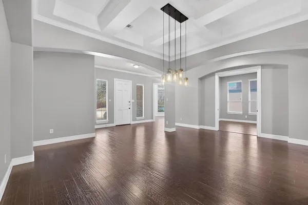 a view of a livingroom with a chandelier wooden floor and a ceiling fan
