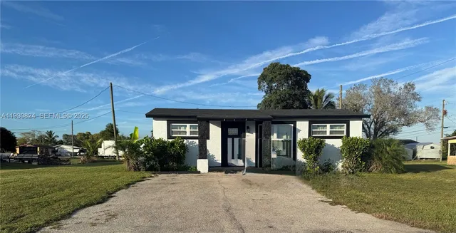 a view of a house with brick walls and a yard with plants