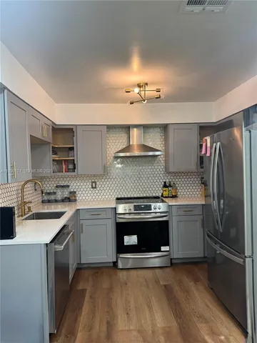 a kitchen with a sink stove and refrigerator