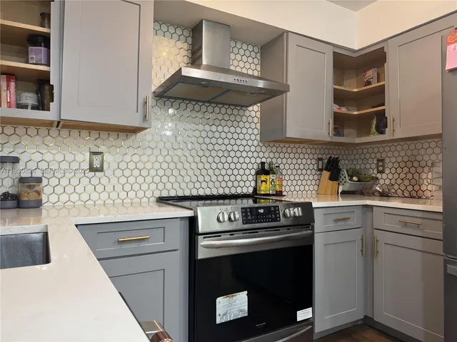 a kitchen with stainless steel appliances granite countertop a stove a sink and a microwave