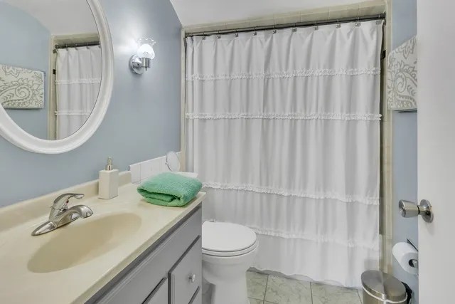 a bathroom with a sink vanity mirror and toilet