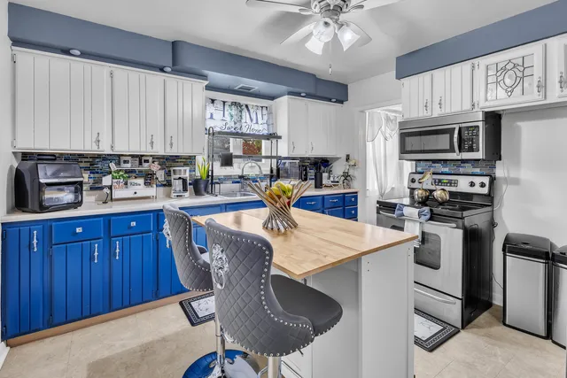 a kitchen with stainless steel appliances kitchen island granite countertop a sink dishwasher stove and refrigerator with wooden cabinets