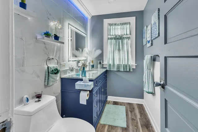 a bathroom with a granite countertop toilet sink and mirror