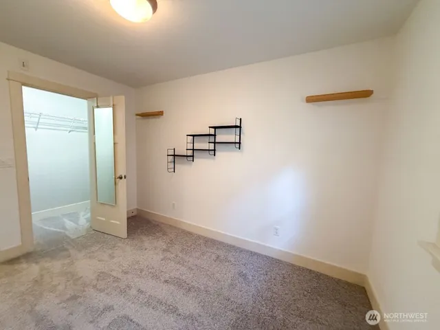 an empty room with closet and windows