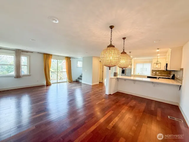 a view of open kitchen with furniture and wooden floor