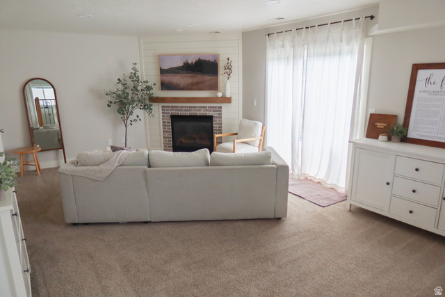 1204 North 3020th Street West Provo, UT 84601 - Photo 19 of 35 Living area featuring a brick-surround fireplace with a wood mantle, shiplap accent wall, and patio access via a sliding glass door
