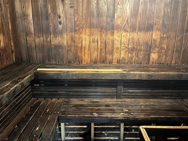 a outdoor sitting area with chairs a rug and a window