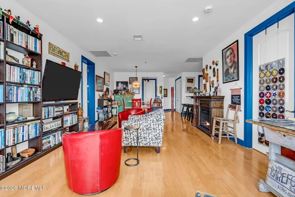 a living room with furniture a flat screen tv and a book shelf