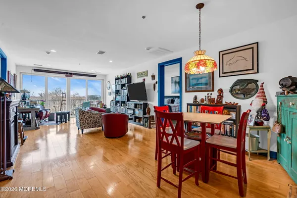 a view of a dining room and livingroom with furniture wooden floor a chandelier