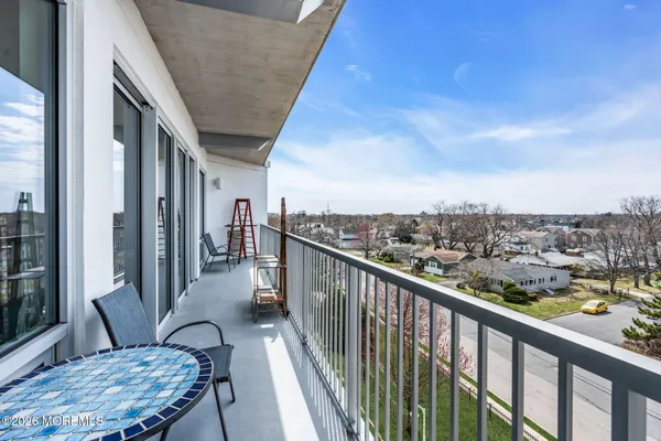 a view of a balcony with chairs and wooden fence