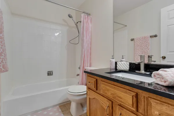 a bathroom with a granite countertop sink a toilet and a bathtub