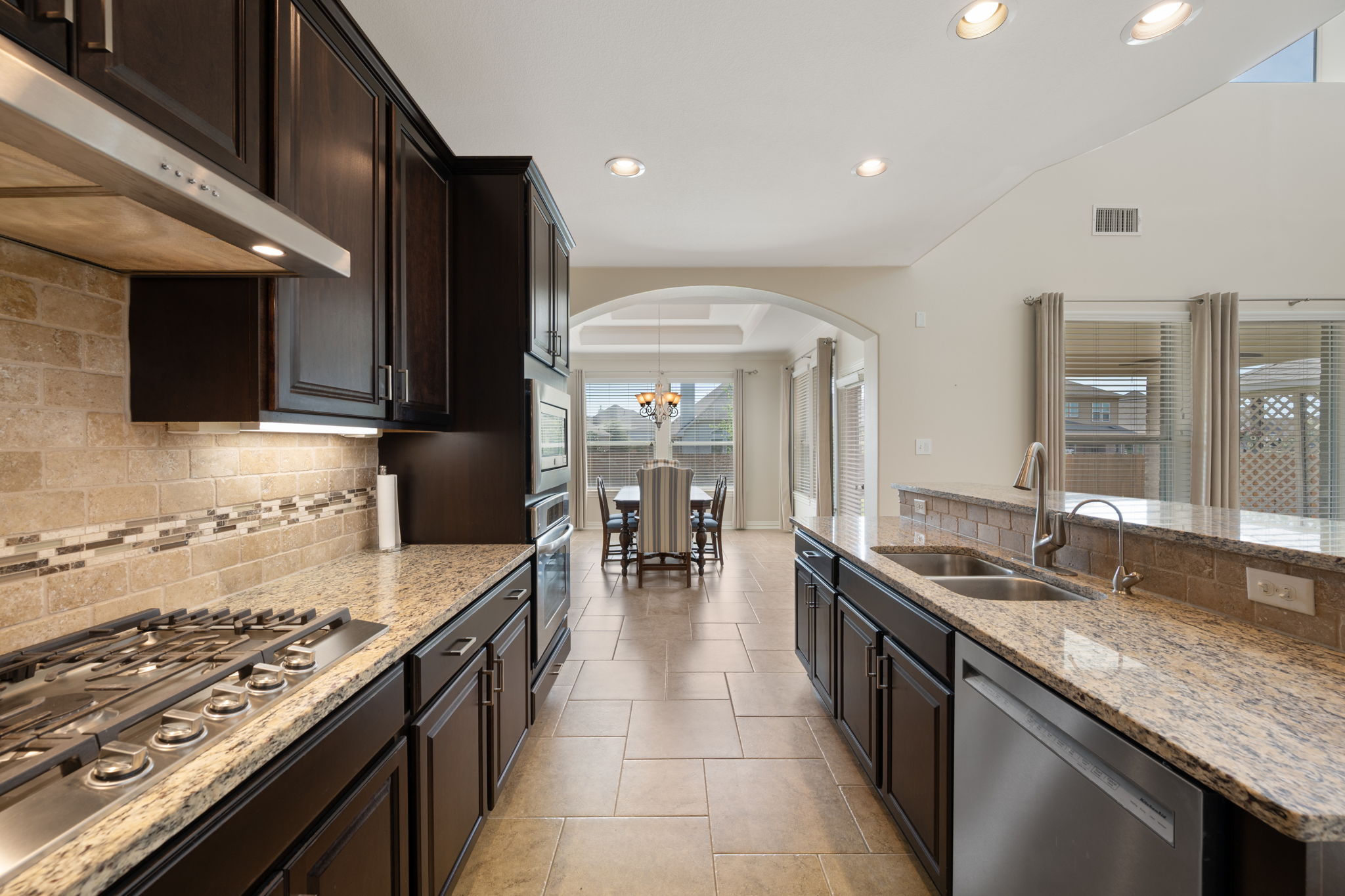 3904 Brean Down Road Pflugerville, TX 78660 - Photo 10 of 40 Kitchen with arched walkways, tasteful backsplash, and light stone countertops