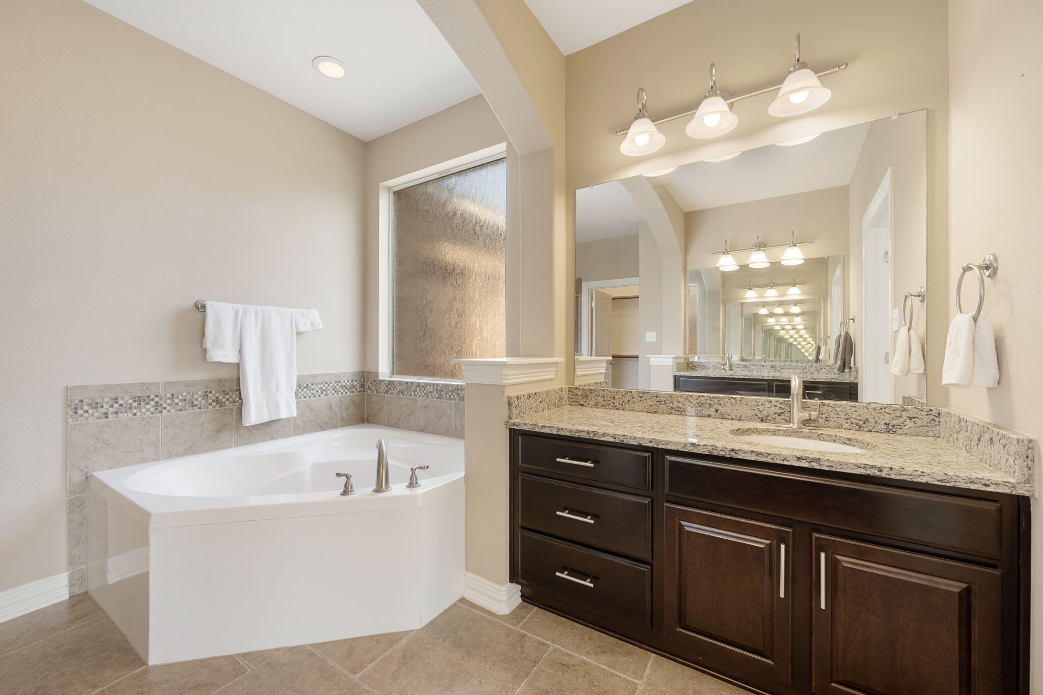 3904 Brean Down Road Pflugerville, TX 78660 - Photo 15 of 40 Bathroom featuring vanity, a bath, and light tile patterned floors