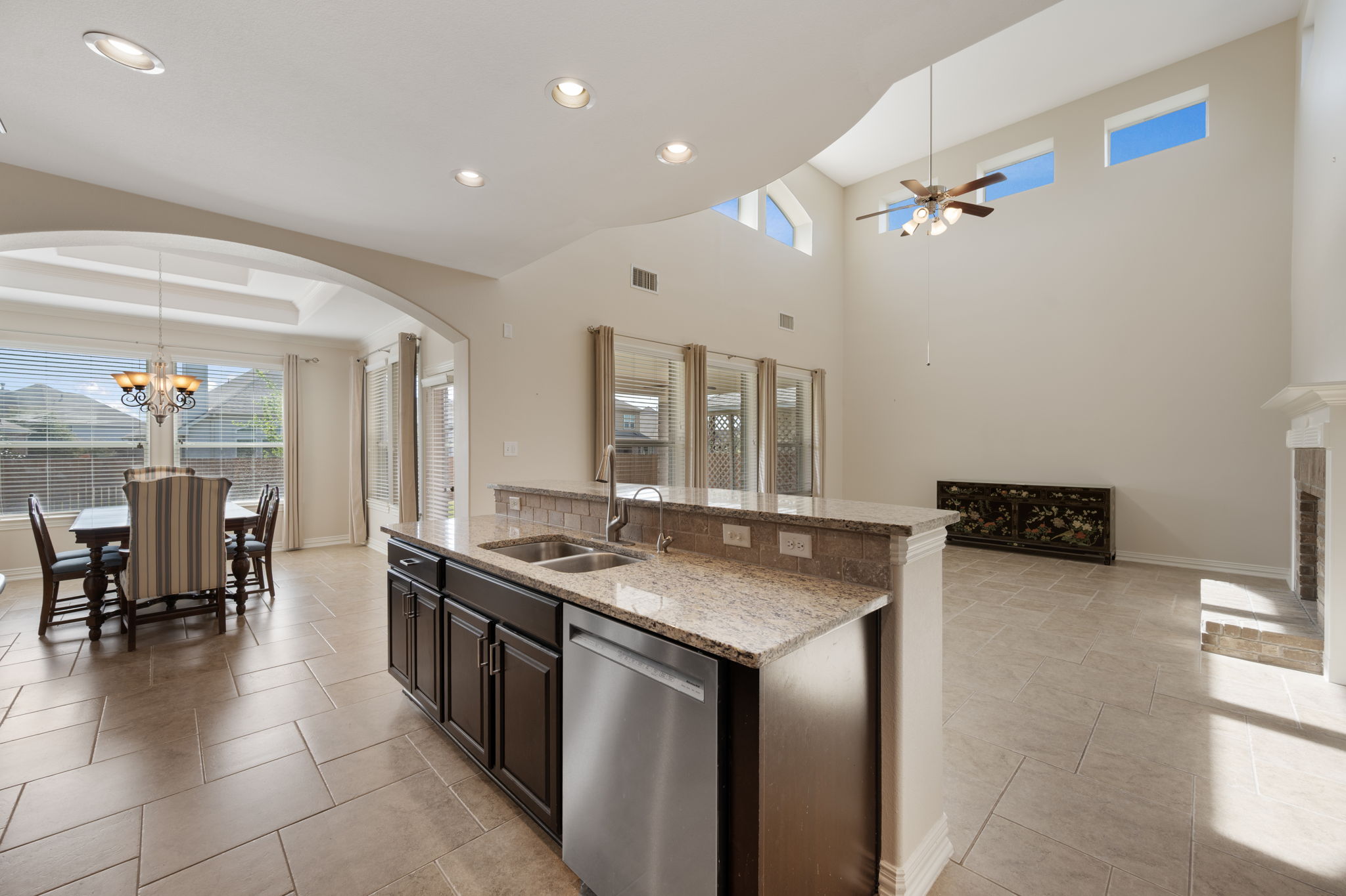 3904 Brean Down Road Pflugerville, TX 78660 - Photo 39 of 40 Kitchen with arched walkways, light stone countertops, dishwasher, a center island with sink, and open floor plan