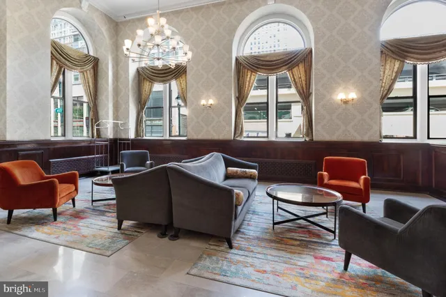a living room with furniture a chandelier and a large window