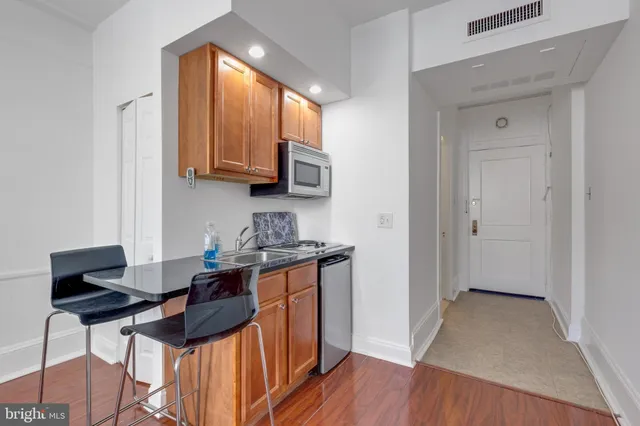a kitchen with a sink cabinets and wooden floor