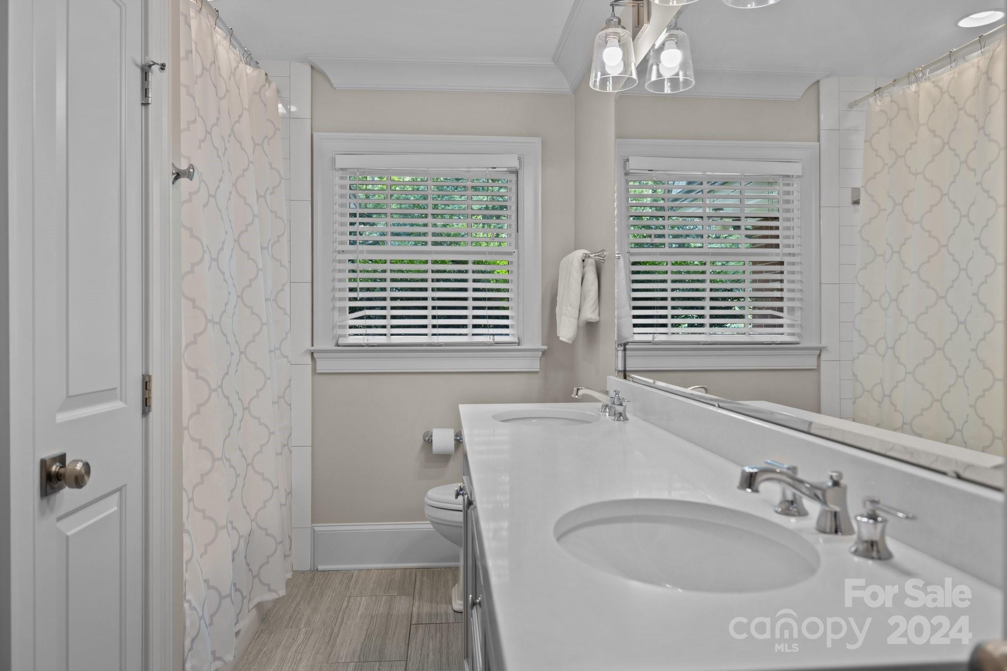 2414 Inverness Road Charlotte, NC 28209 - Photo 21 of 46 a bathroom with a sink a mirror and a window