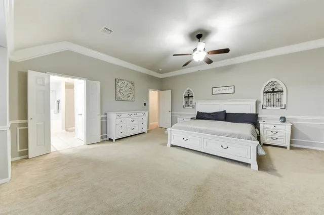 a spacious bedroom with a large bed and a chandelier
