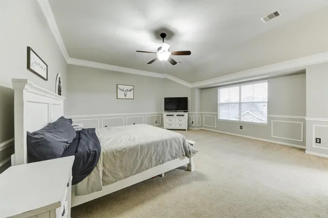 a spacious bedroom with a bed and a ceiling fan