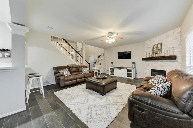 a living room with furniture a fireplace and a flat screen tv