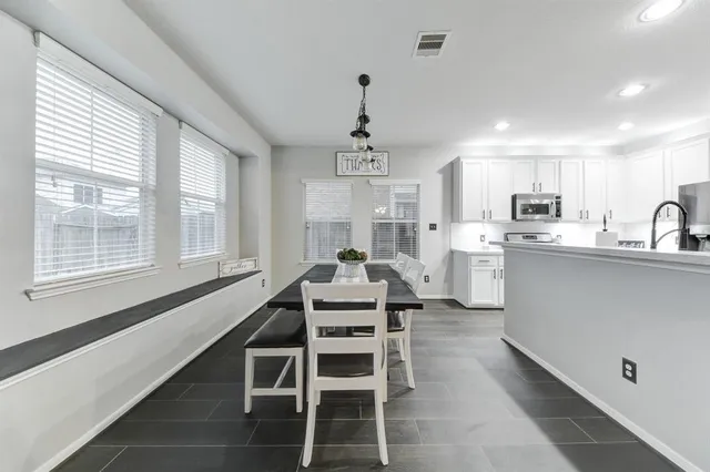 a kitchen with kitchen island granite countertop a sink stainless steel appliances and window