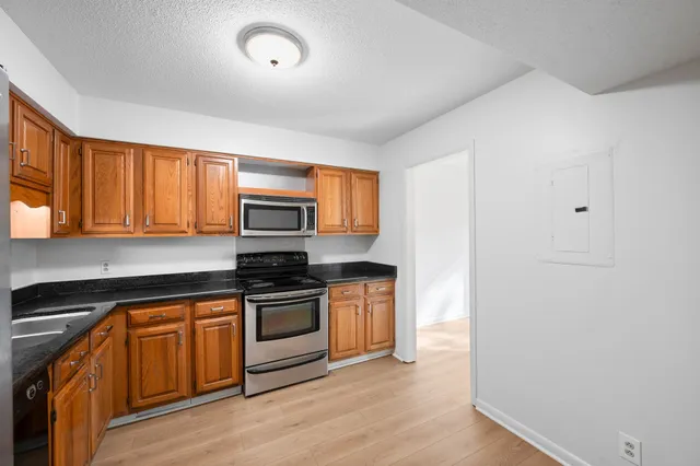 a kitchen with stainless steel appliances granite countertop a stove a sink and a microwave