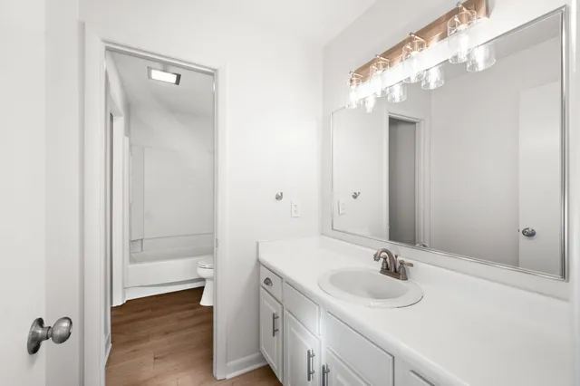 a bathroom with a sink vanity granite and a mirror