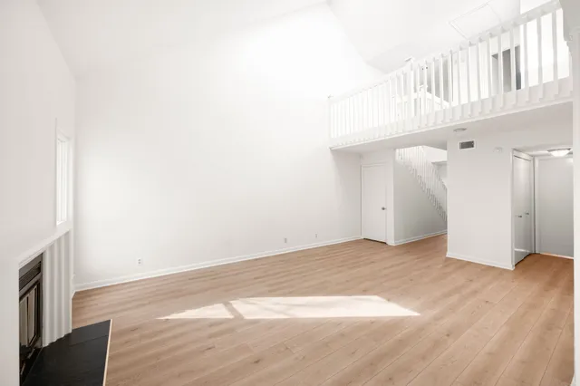 a view of an empty room with wooden floor