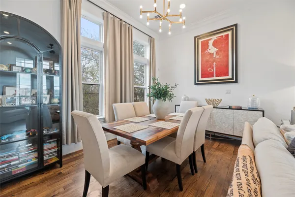 a kitchen with stainless steel appliances granite countertop a stove top oven a sink dishwasher a dining table and chairs with wooden floor