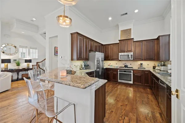 a kitchen with stainless steel appliances granite countertop a sink refrigerator and cabinets