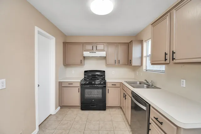 a kitchen with stainless steel appliances granite countertop a stove a sink and a refrigerator