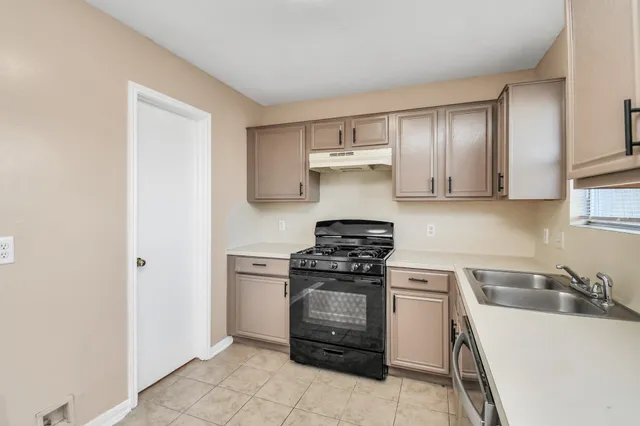 a kitchen with a stove top oven and cabinets