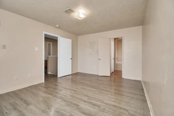 a view of an empty room with wooden floor