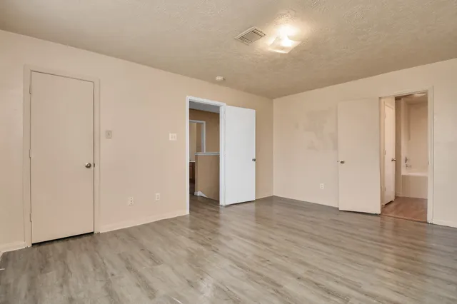 a view of an empty room with wooden floor