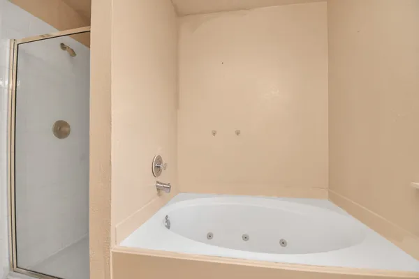 a white bath tub sitting next to a shower
