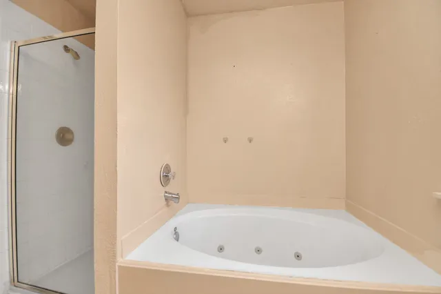 a white bath tub sitting next to a shower