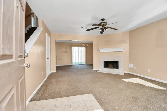 a view of a livingroom with a fireplace and chandelier fan