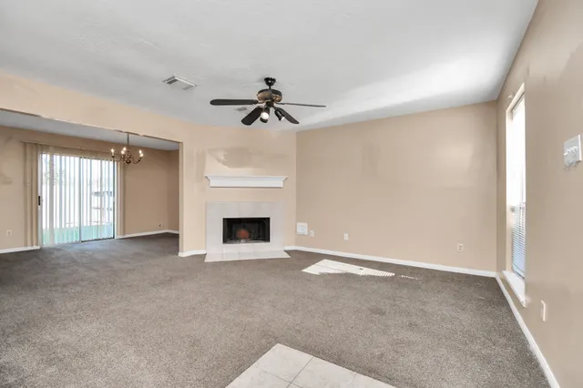 a view of an empty room with a fireplace and a window