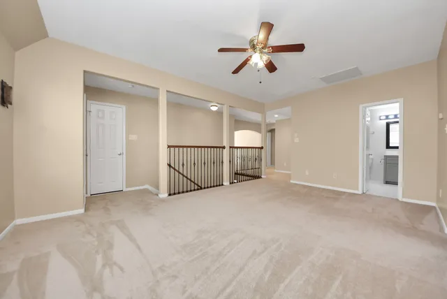 an empty room with windows and fan