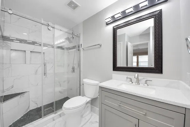 a bathroom with a sink a toilet and a mirror