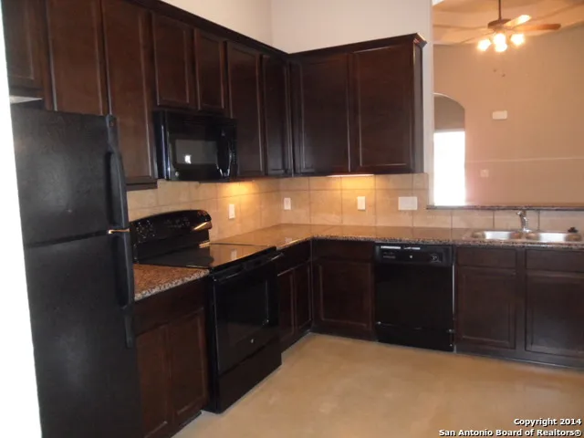 a kitchen with stainless steel appliances granite countertop a refrigerator and a stove top oven