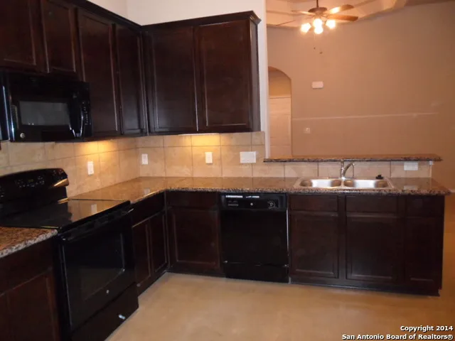 a kitchen with granite countertop a stove and a refrigerator