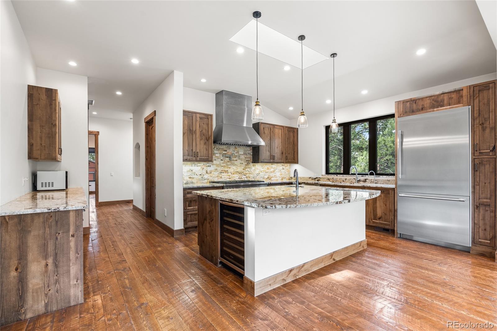 280 Double Tree Road Bailey, CO 80421 - Photo 12 of 43 a kitchen with kitchen island a sink stainless steel appliances and wooden floor